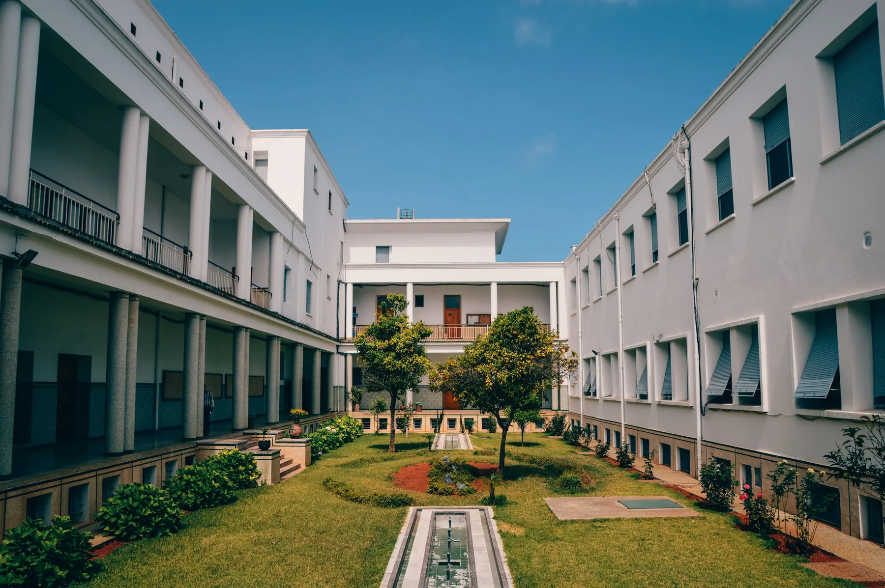 A colonnaded academic building around a planted courtyard